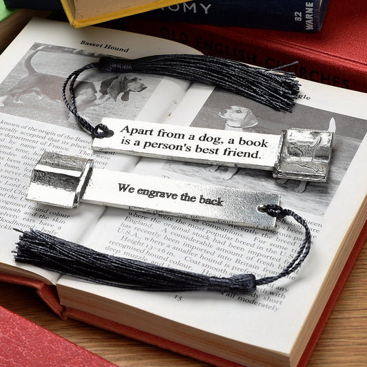 A personalised engraved pewter metal  bookmark with a dog silhouette on an open book on the top. On the front the quotation 'Apart from a dog, a book is a person's best friend'. We engrave the back with your message. Gifts For Dog Lovers, book lovers gifts, dog gifts.