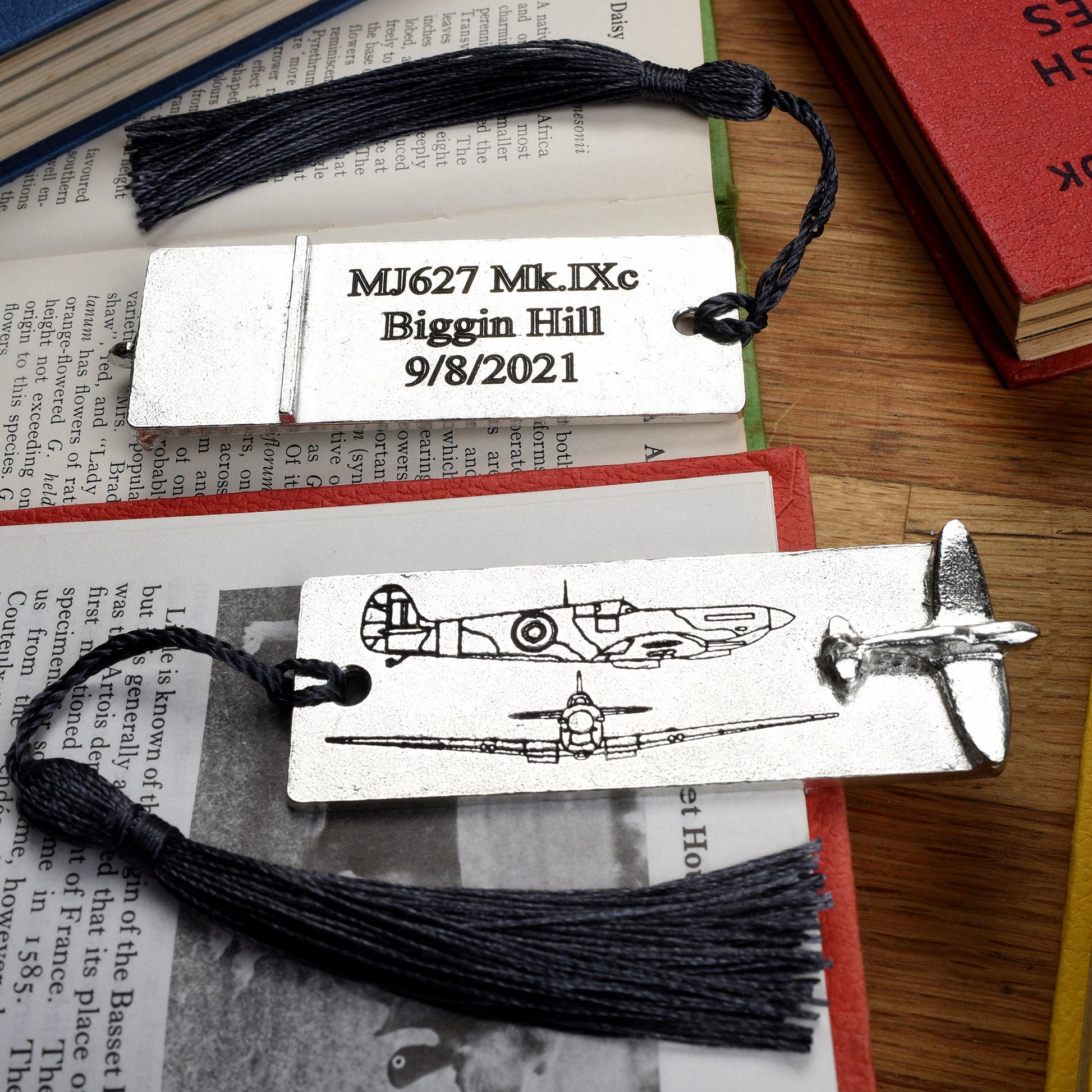 A personalised engraved pewter metal  bookmark with a Spitfire aeroplane sculpture on the top. On the front are blueprint drawings of a mark IX Spitfire. We engrave the back with your message. Personalised Spitfire gifts.