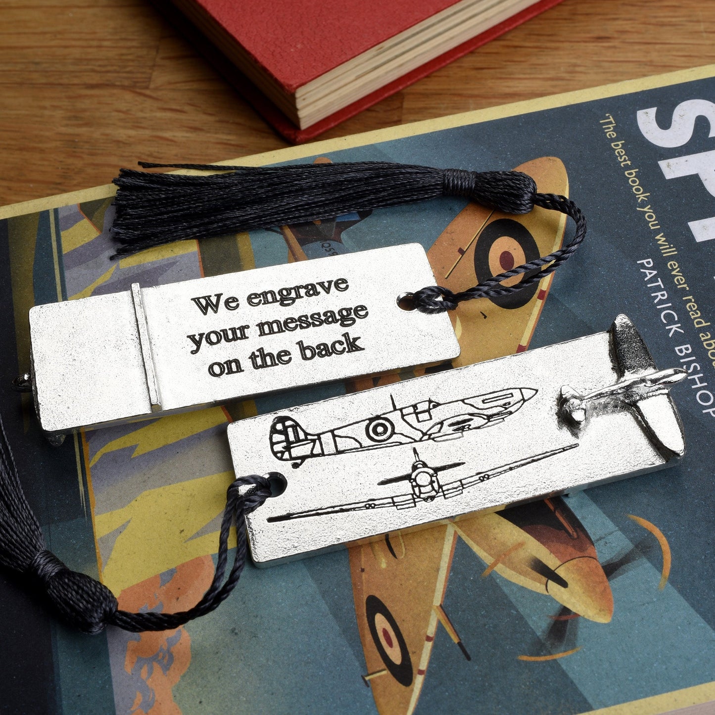 A personalised engraved pewter metal  bookmark with a Spitfire aeroplane sculpture on the top. On the front are blueprint drawings of a mark IX Spitfire. We engrave the back with your message. Personalised Spitfire gifts.