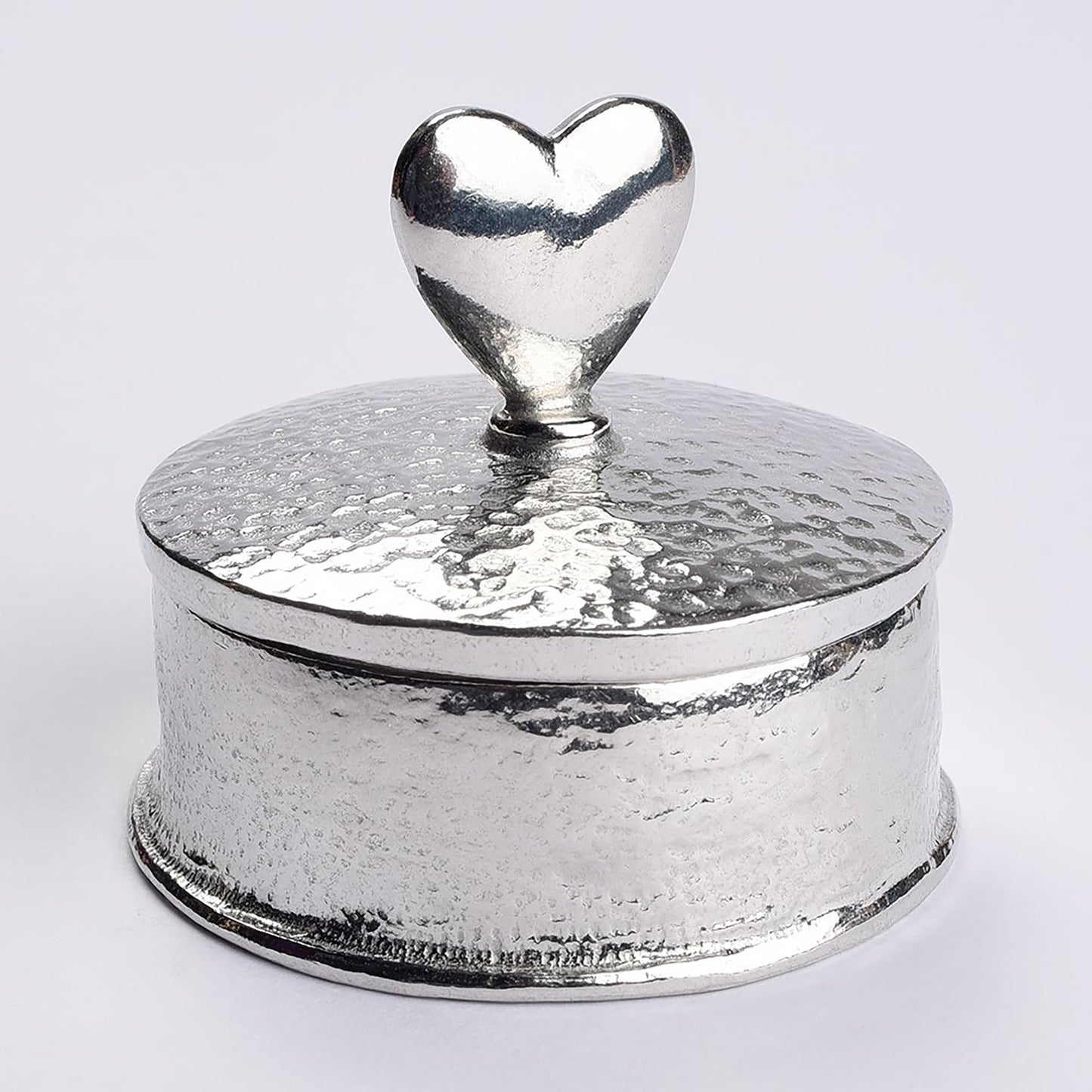 Heart 10th wedding anniversary pewter personalised trinket box gift. Our round anniversary keepsake box features a heart sculpture as a handle. The underside of the lid can be engraved with your message. A perfect tin ten year  anniversary gift (Our pewter is 95% tin)