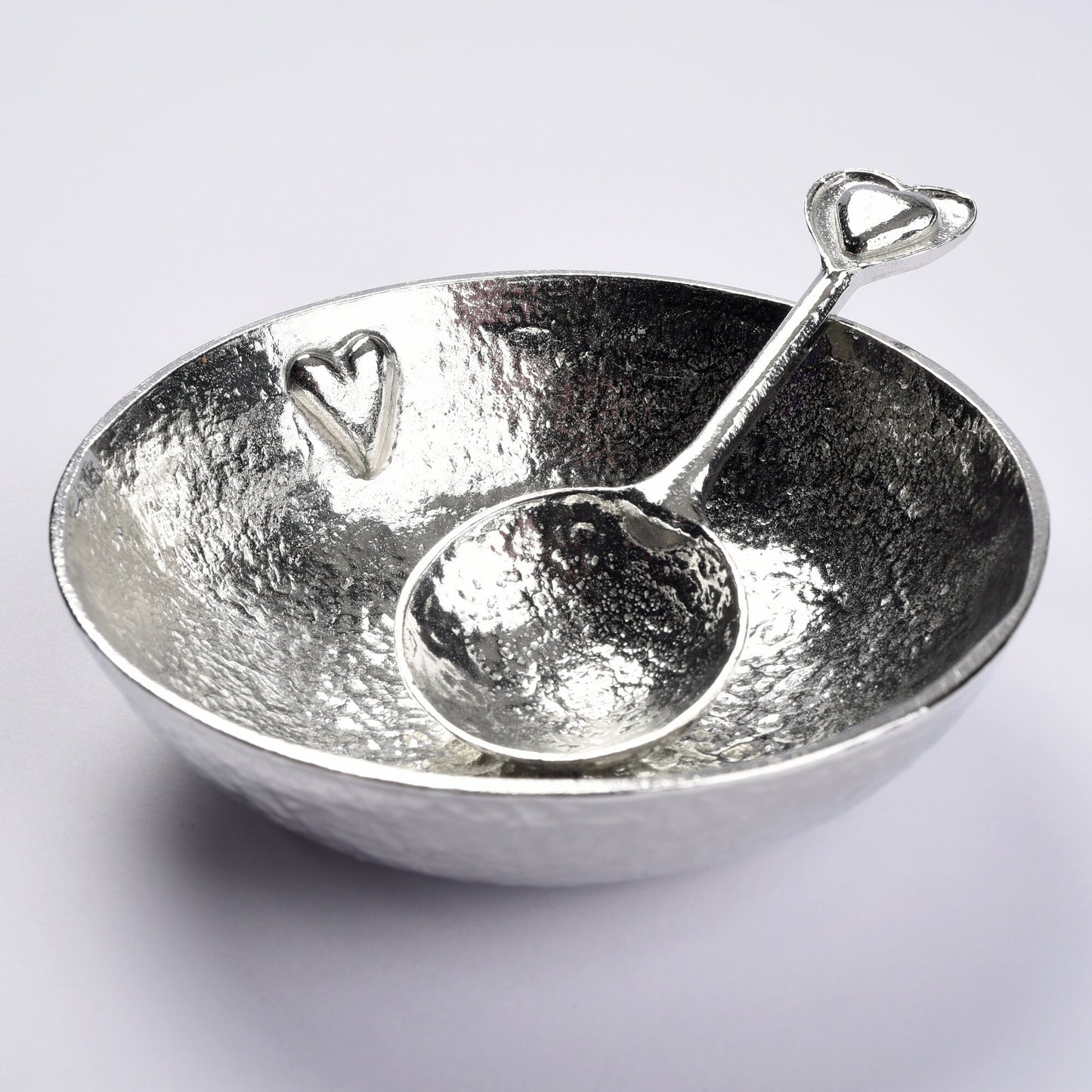 A 9cm diameter textured, circular pewter bowl, with a beautiful, yet subtle heart on the inside of the dish, comes with an accompanying heart love spoon. A perfect 10th (Tin) ten year wedding anniversary gift (Our pewter is 95% tin).