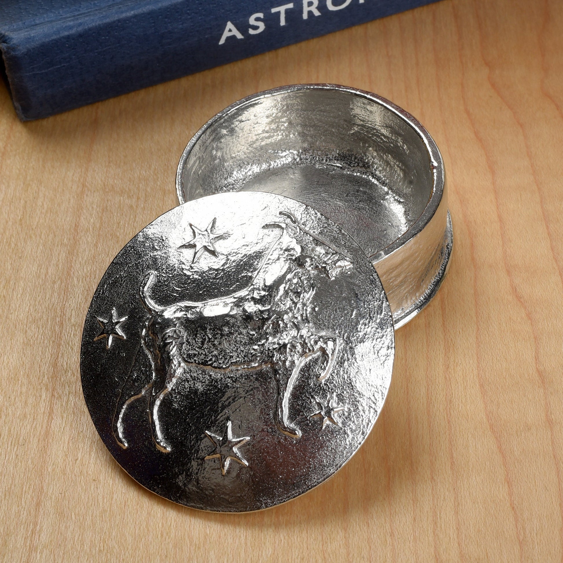 A beautifully detailed and textured Capricorn goat zodiac sign guards precious treasure on this personalised pewter trinket box. The underside of the lid can be engraved with your personalised message. Birthday gifts for Capricorns - made in Britain.