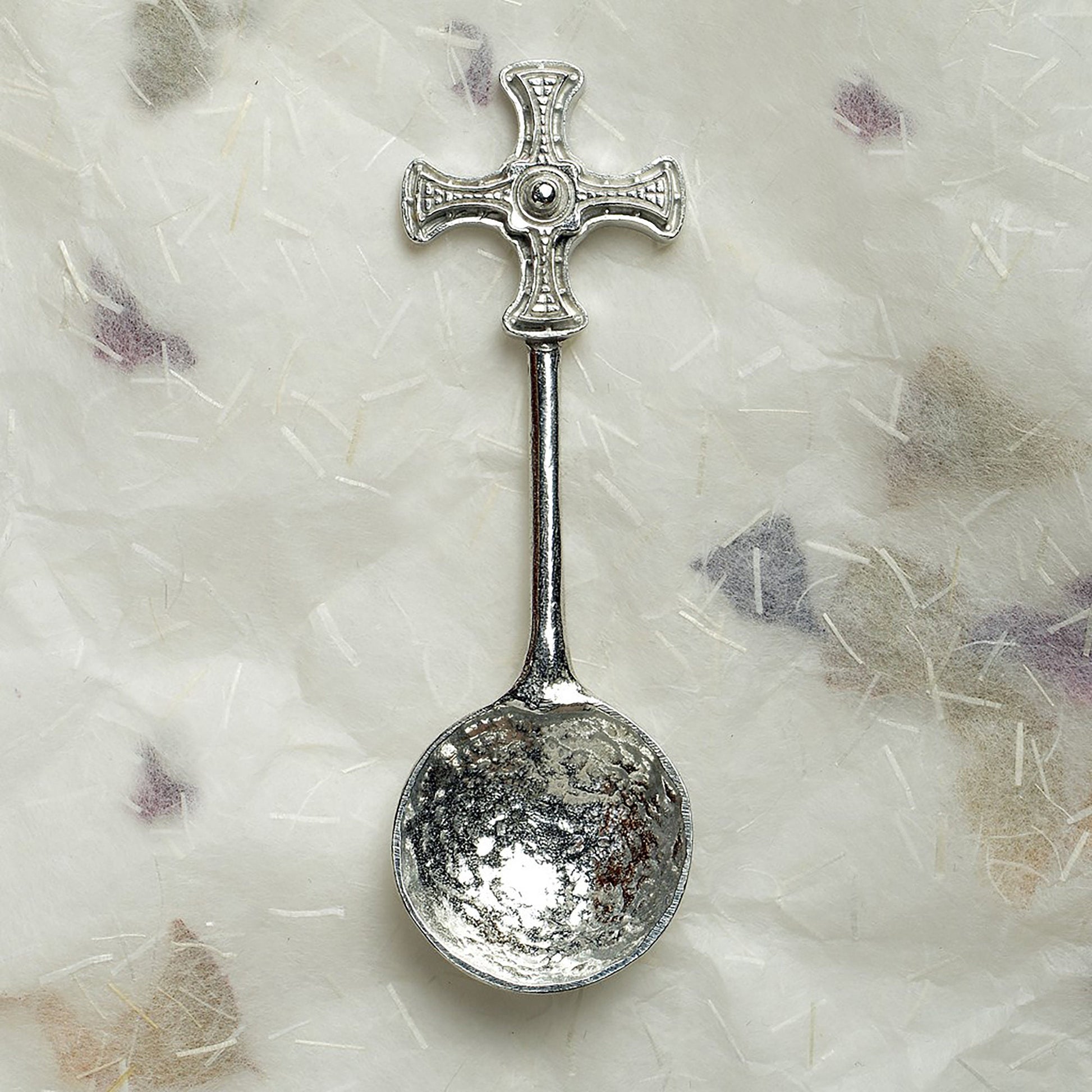 A small spoon pewter sugar spoon with Durham cathedral's St Cuthbert Cross on the end of a straight handle. Christening gifts for boys and girls