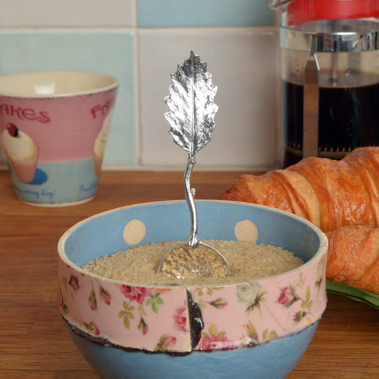 A small spoon pewter sugar spoon with a detailed chestnut leaf on the end of a twig handle. Unusual, useful and tactile gifts for nature lovers handmade in the UK