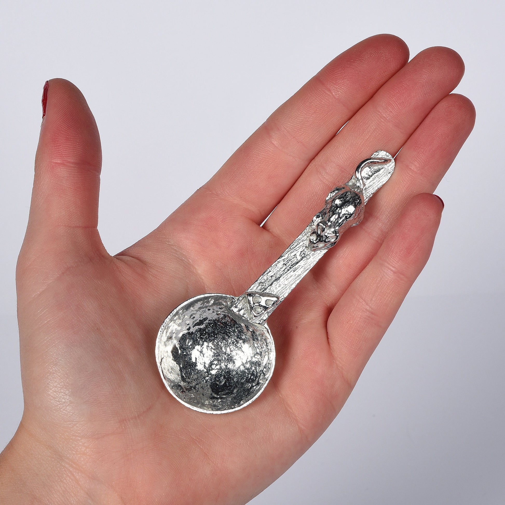 A small spoon pewter sugar spoon. A round bowled spoon leads to a wood textured stem with a mouse chasing a wedge of cheese. Practical & useful mouse gifts for nature lovers. UK handmade