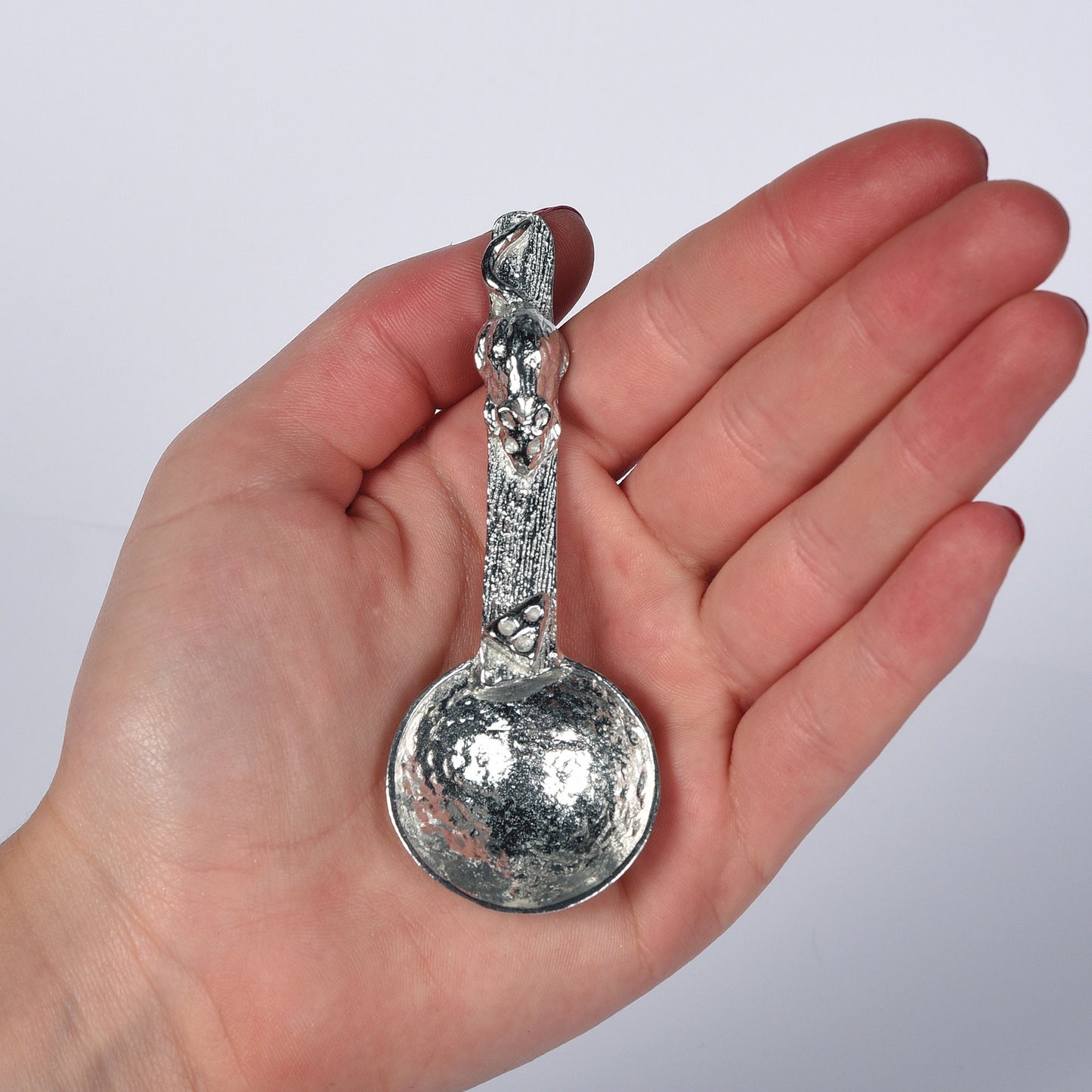 A small spoon pewter sugar spoon. A round bowled spoon leads to a wood textured stem with a mouse chasing a wedge of cheese. Practical & useful mouse gifts for nature lovers. UK handmade