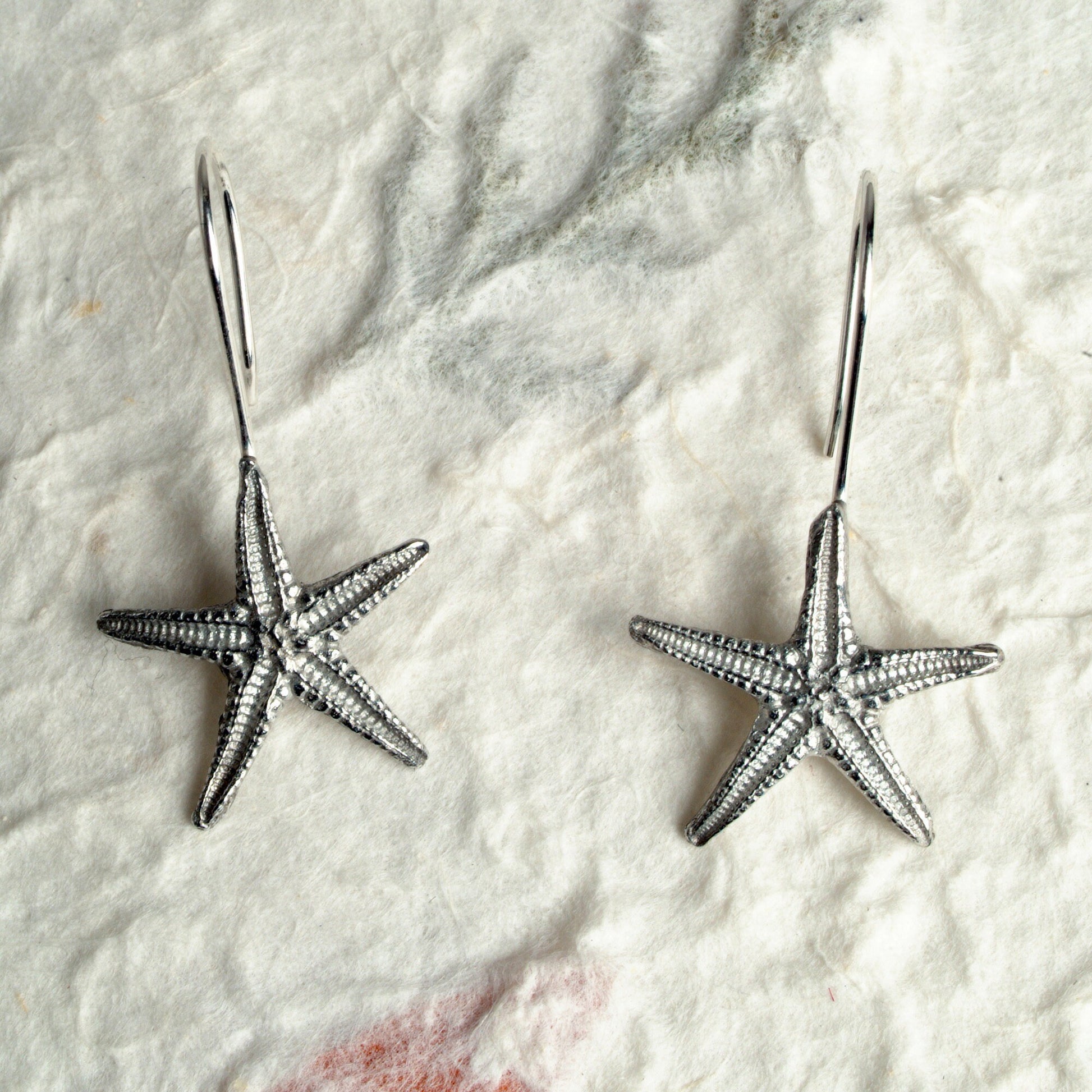 Starfish drop earrings, pewter starfishes on Sterling silver ear hooks. Pewter and silver starfish jewellery gifts, handmade in the UK by Glover and Smith