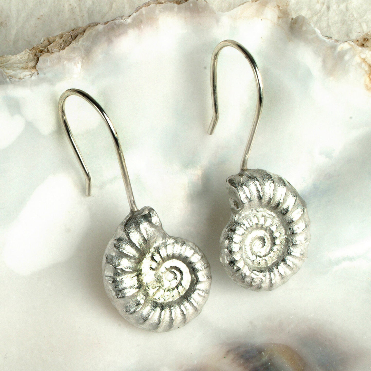 Ammonite drop earrings, pewter ammonite fossils on Sterling silver ear hooks. Pewter and silver ammonite jewellery gifts, handmade in the UK by Glover and Smith