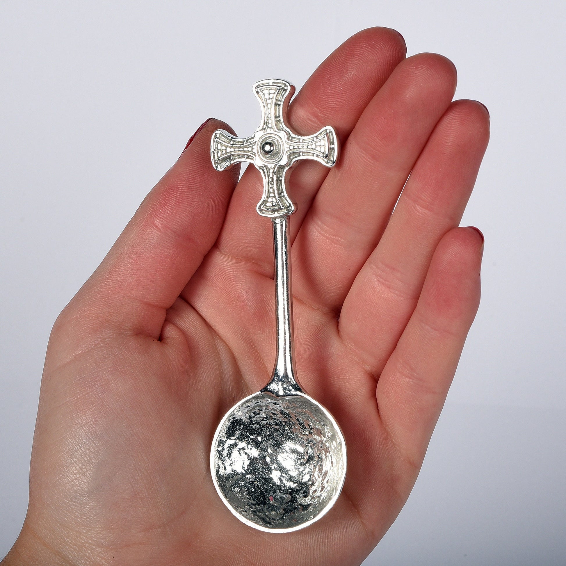 A small spoon pewter sugar spoon with Durham cathedral's St Cuthbert Cross on the end of a straight handle. Christening gifts for boys and girls