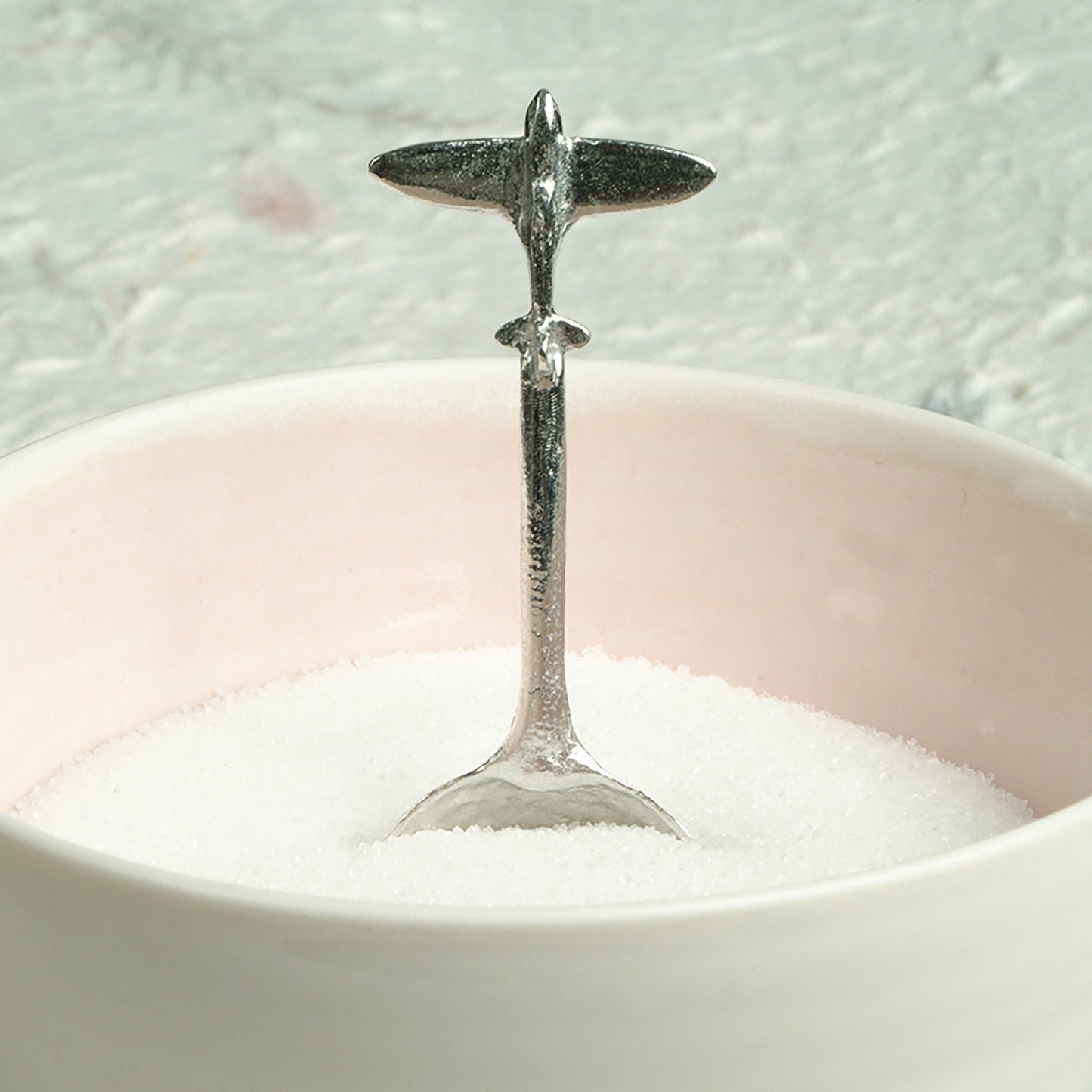 A small spoon pewter sugar spoon. A round bowled spoon on a straight handle leads to a perfectly sculpted spitfire aeroplane. Practical & useful spitfire gifts for spitfire lovers. UK handmade