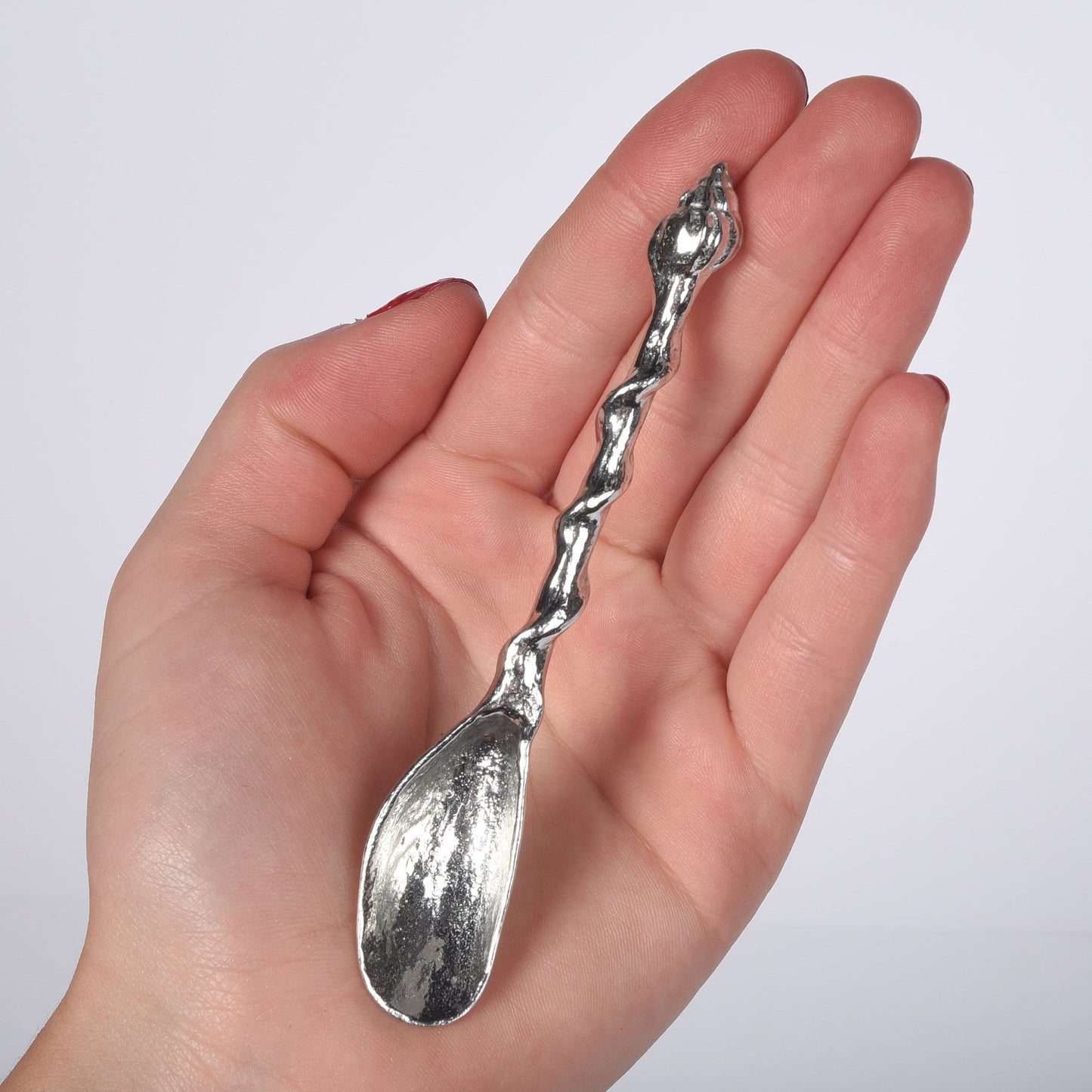 A small spoon pewter sugar spoon. A mussel shell provides the bowl with a twisted stem leading to a seashell. Practical & useful nautical gifts. UK handmade