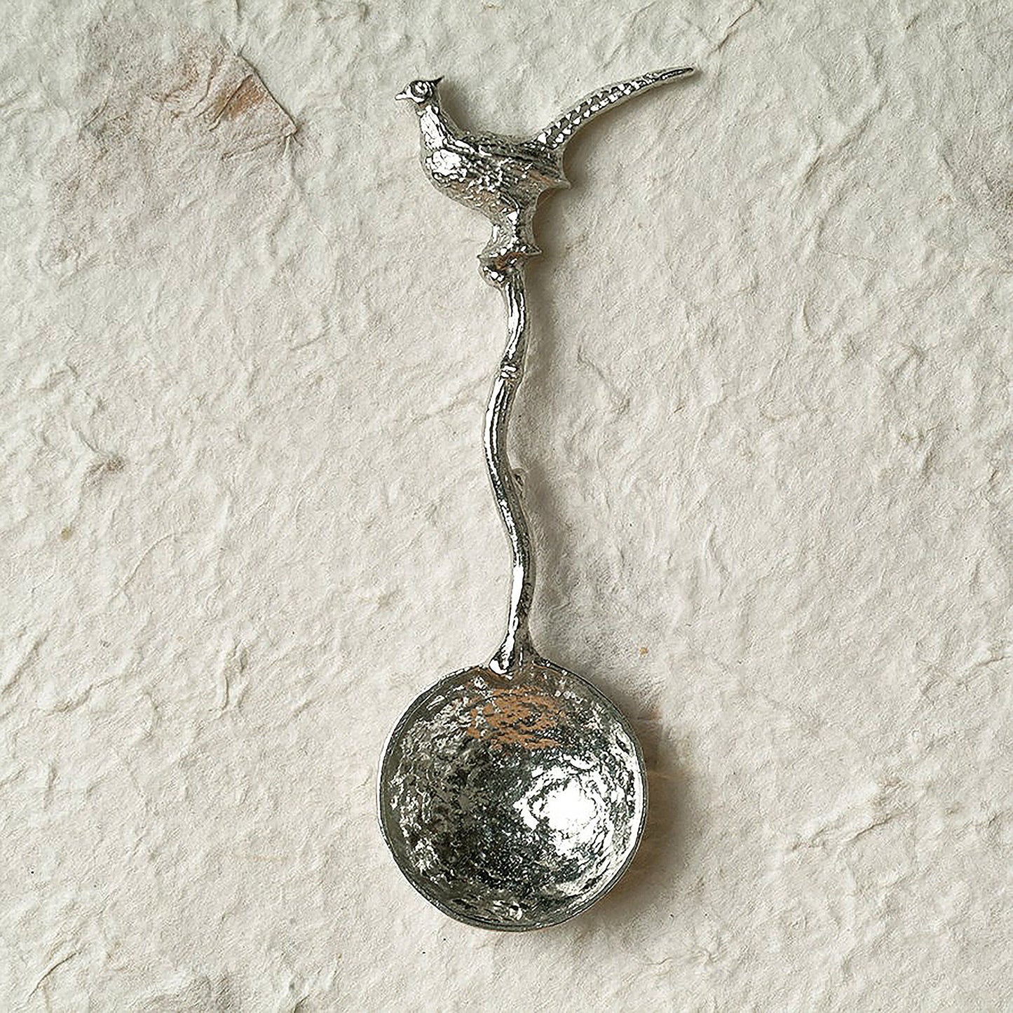 A small spoon pewter sugar spoon with a detailed pheasant on  a twig handle. Unusual, useful and tactile gifts for nature lovers, pheasant shooting gifts handmade in the UK useful countryside gifts