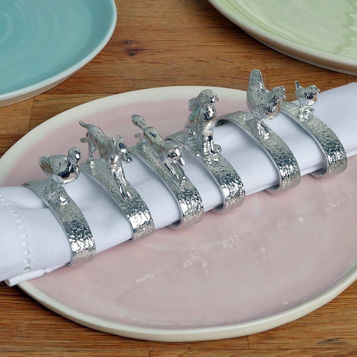 A set of 6 textured pewter oval-shaped napkin rings. Each one has a beautifully observed sculpture of a British countryside animal on top. Perfect country gifts. The set consists of a: fox, hound, chicken, duck, wren and hare.