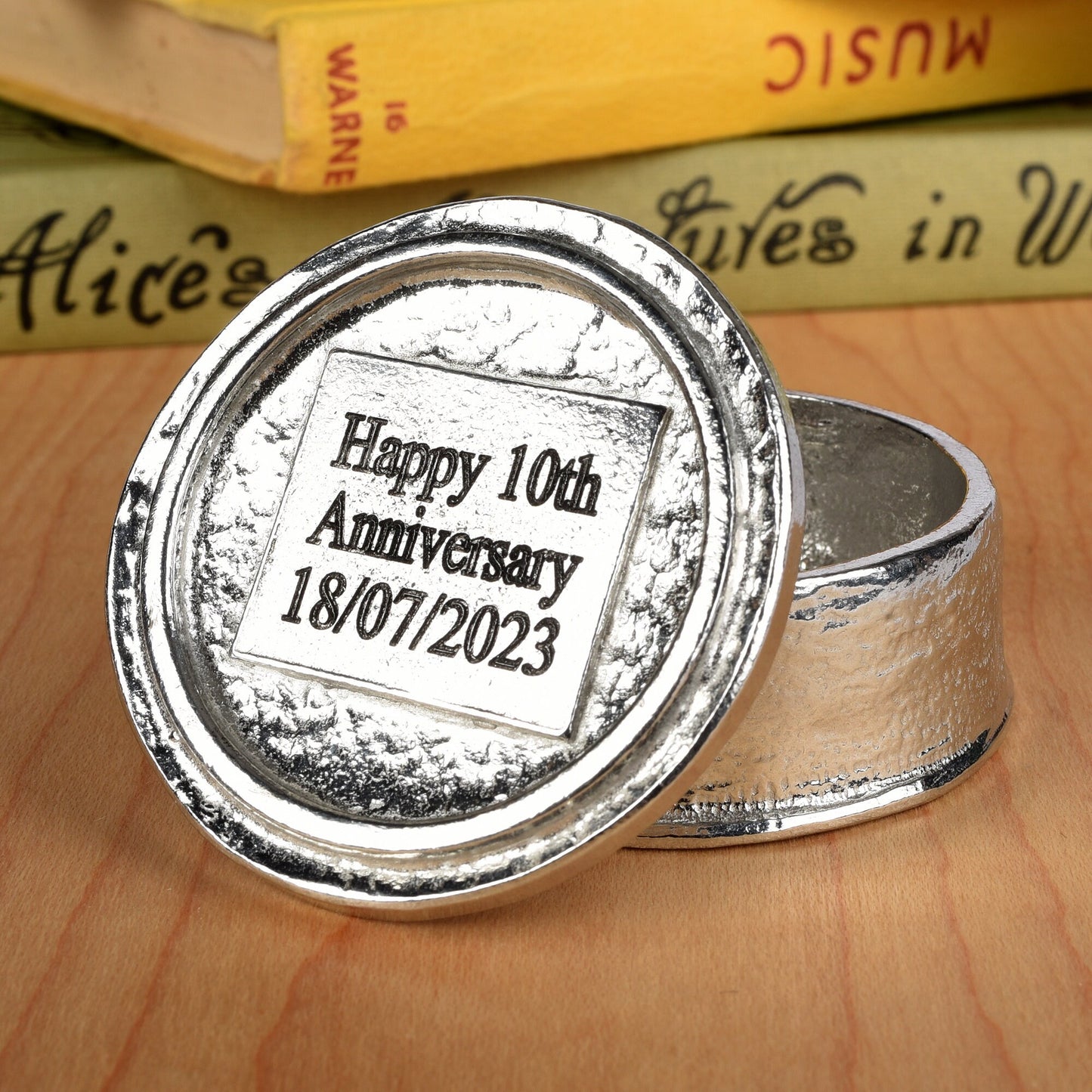 Heart 10th wedding anniversary pewter personalised trinket box gift. Our round anniversary keepsake box features a heart sculpture as a handle. The underside of the lid can be engraved with your message. A perfect tin ten year  anniversary gift (Our pewter is 95% tin)