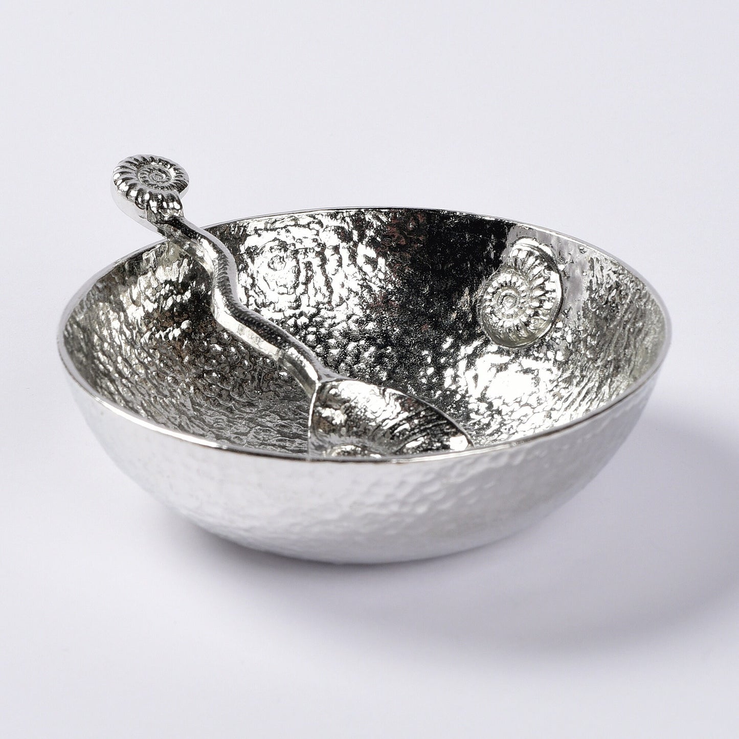 A 9cm diameter beautifully textured circular pewter bowl, with a striking, yet subtle ammonite fossil on the inside of the dish, comes with accompanying ammonite  fossil spoon. Gifts For Fossil Lovers