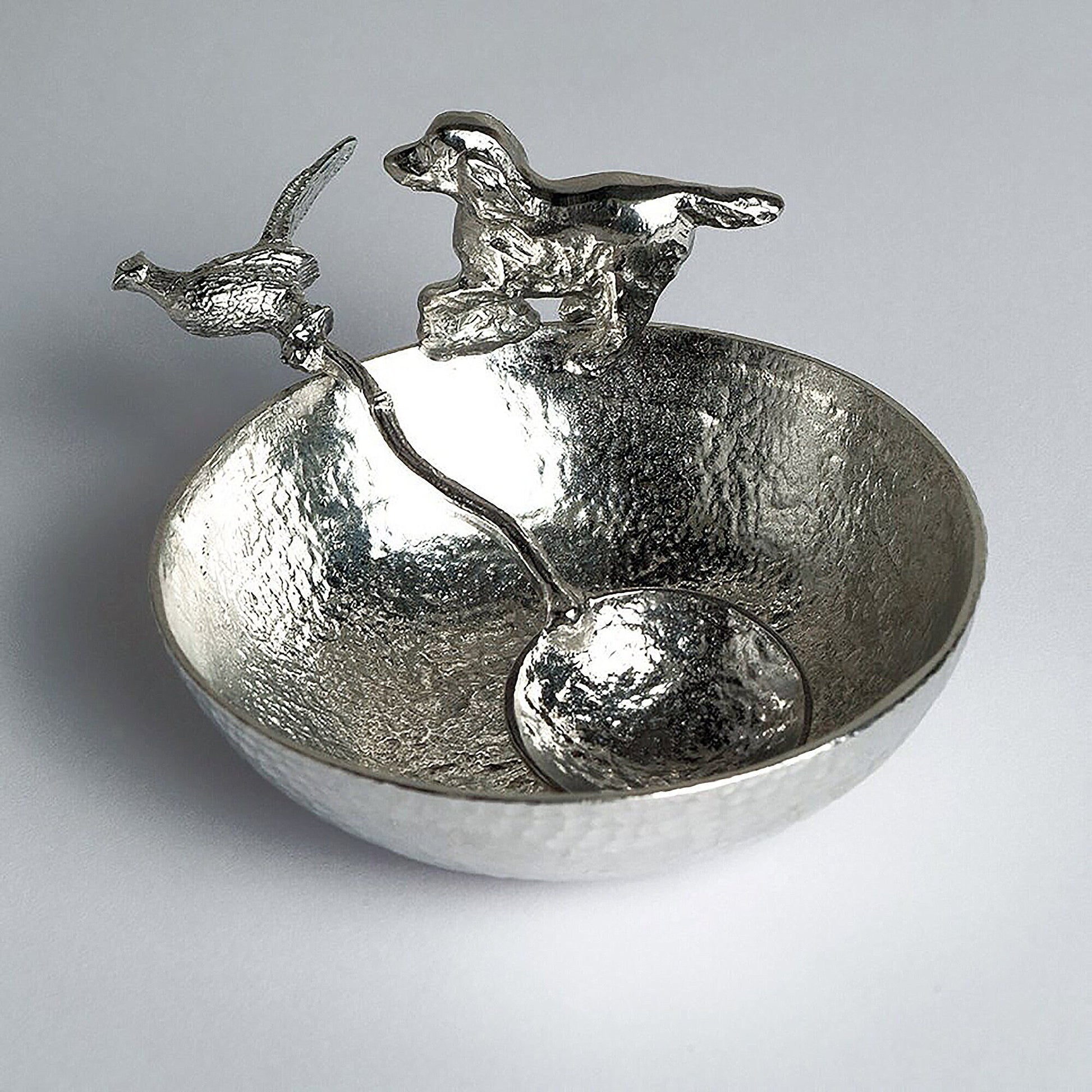 A 9cm diameter textured circular pewter bowl, with a springer spaniel bounding around the edge of the bowl, comes with accompanying pheasant spoon. Great spaniel gifts. Dog Lover Gifts, country gifts UK handmade.