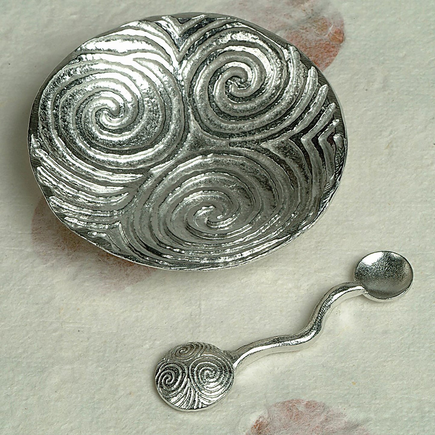 Spiral of life pewter bowl and spoon set. Its design is based on the the triple spiral (or triskele) often called the Spiral of Life as found carved on the entrance stone at Newgrange in Ireland. With matching spirals spoon. Celtic spiral gifts.