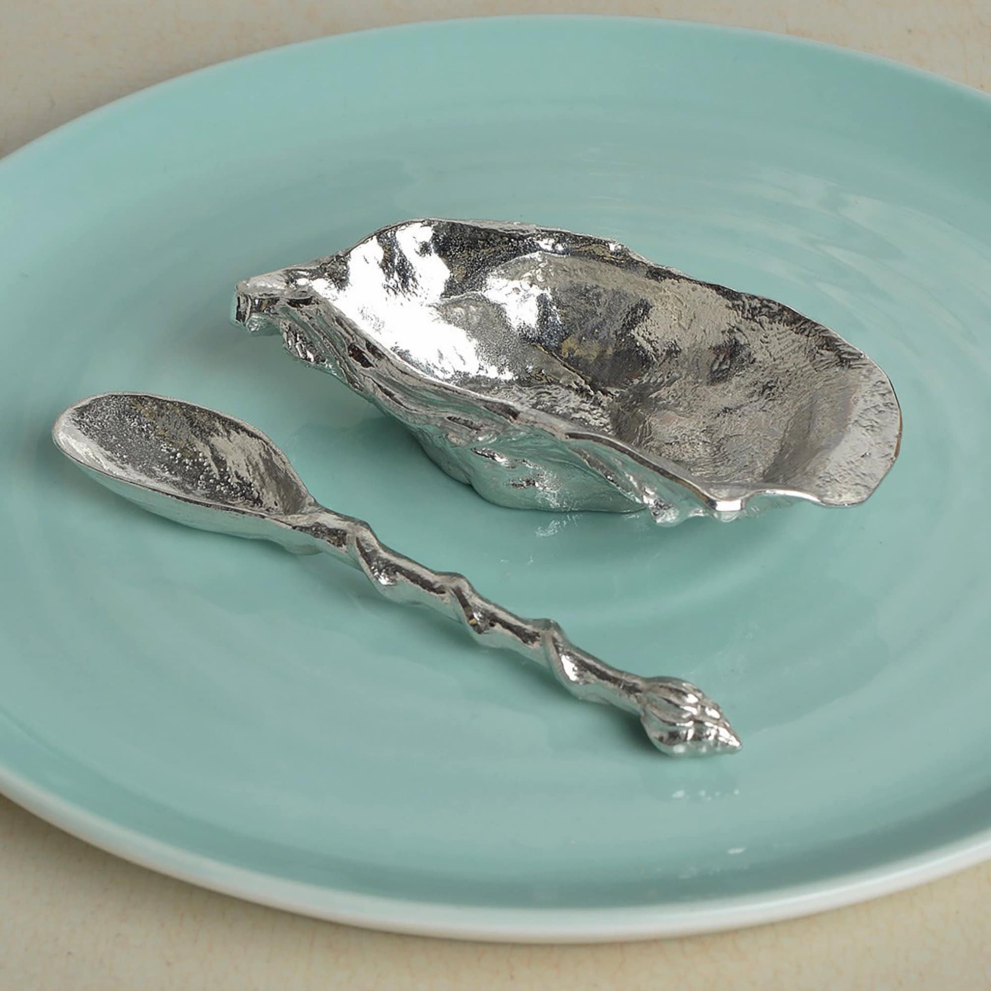 A beautifully detailed pewter oyster shell shaped bowl and mussel spoon set. The silver coloured oyster bowl is ideal for sea salt, sugar, mustard etc. The accompanying spoon has a mussel shell bowl and a small shell finial on an entwining stem.